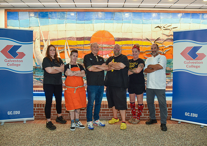 6 chefs pose for a photo with arms crossed at Galveston College.