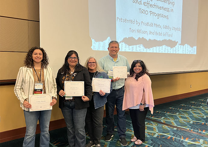 5 people stand with certificates at conference