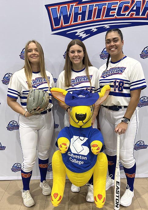 Three softball players with mascot.