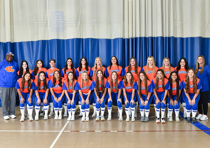 Softball team poses for photo in uniforms