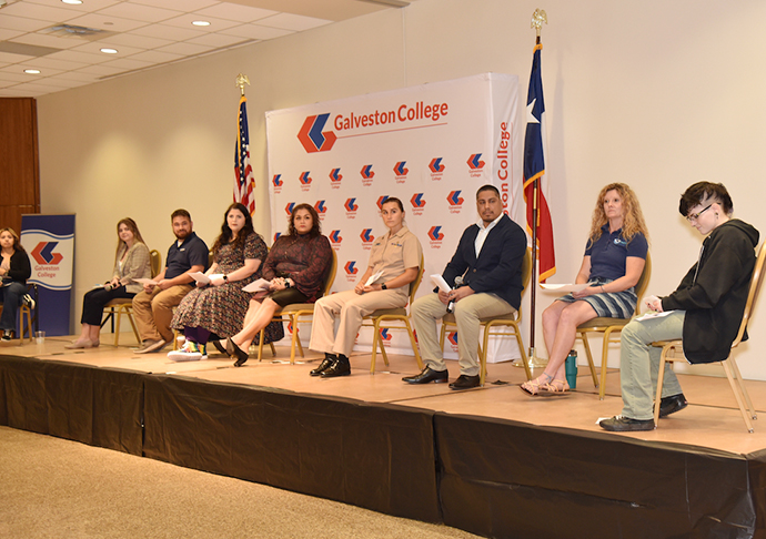 Seven panelists sit on a stage with a host to discuss STEM careers.