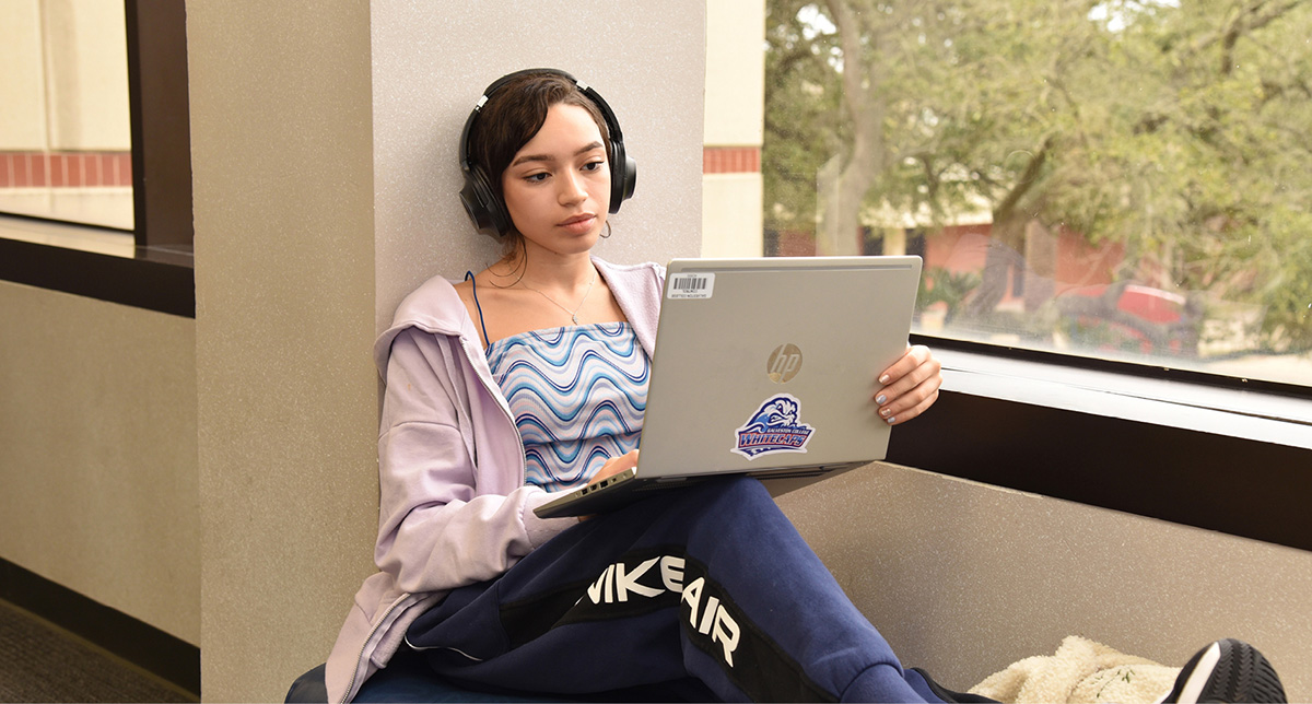 Student on laptop in hallway