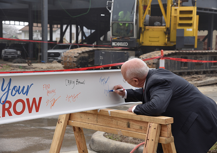 College President - Dr. Shelton signing beam